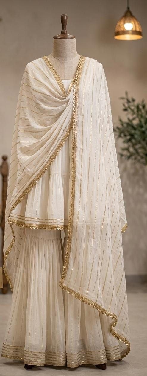 elegant off-white ethnic set features a fine interplay of subtle metallic stripes and delicate gold